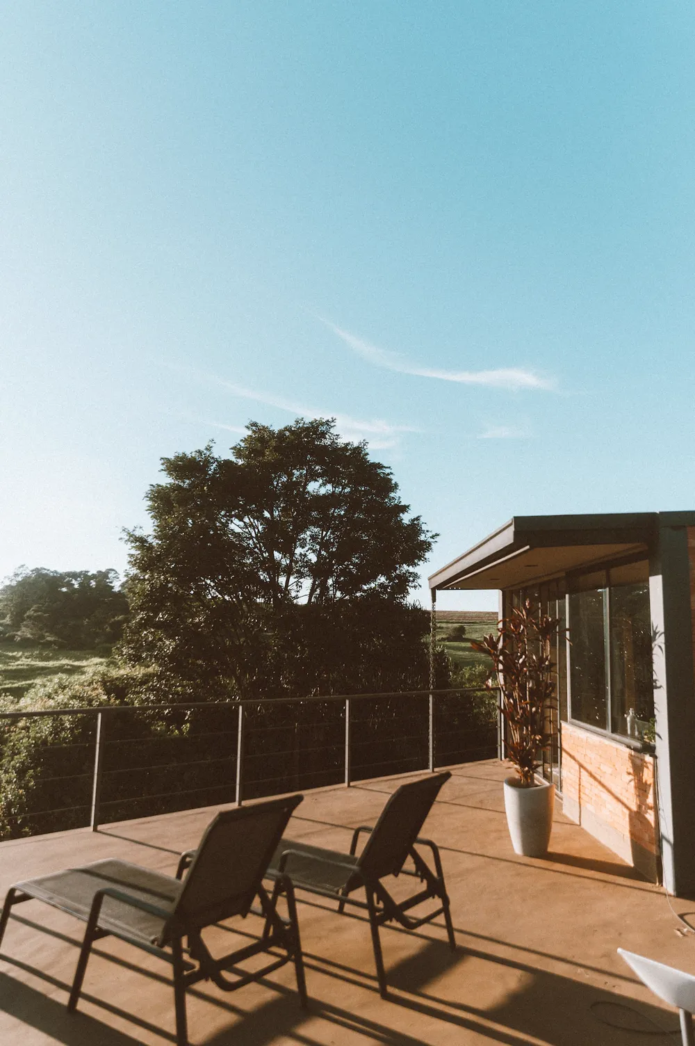 Duas espreguiçadeiras no deck com vista para as árvores