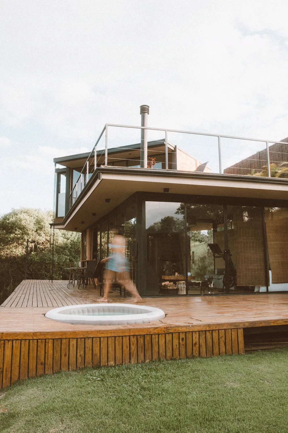 Fachada da microcasa com deck, ofurô e gramado